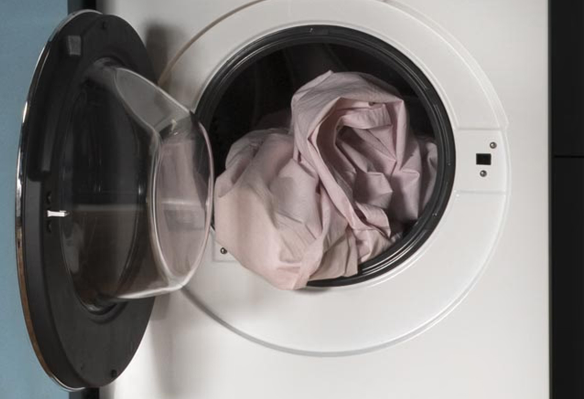 Απεικονίζεται η συσκευή με ανοιχτό κάδο και ρούχο μέσα.